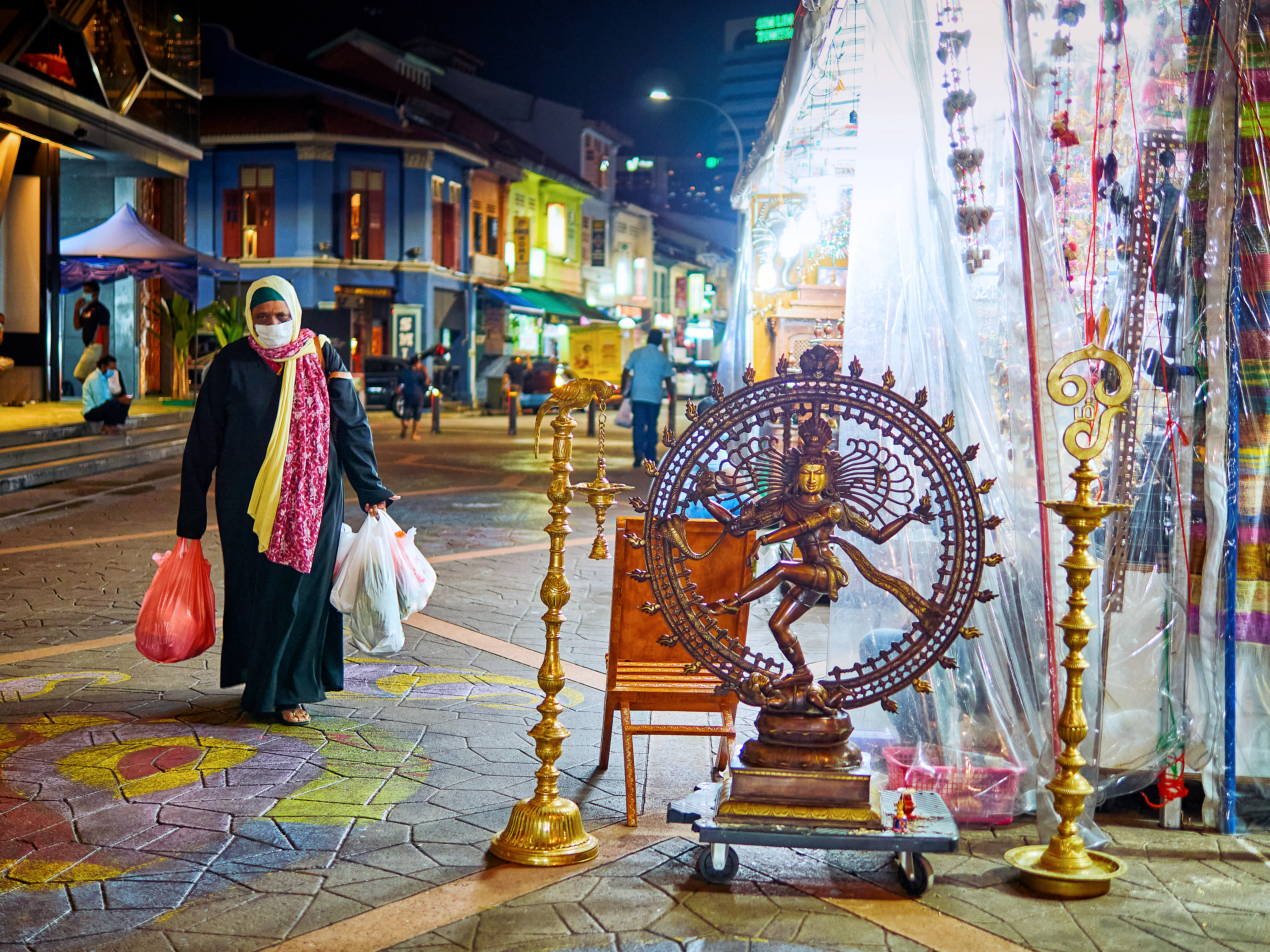 Nataraja Statue on display and one woman walking by after her shopping, a street scene at Little India, Singapore