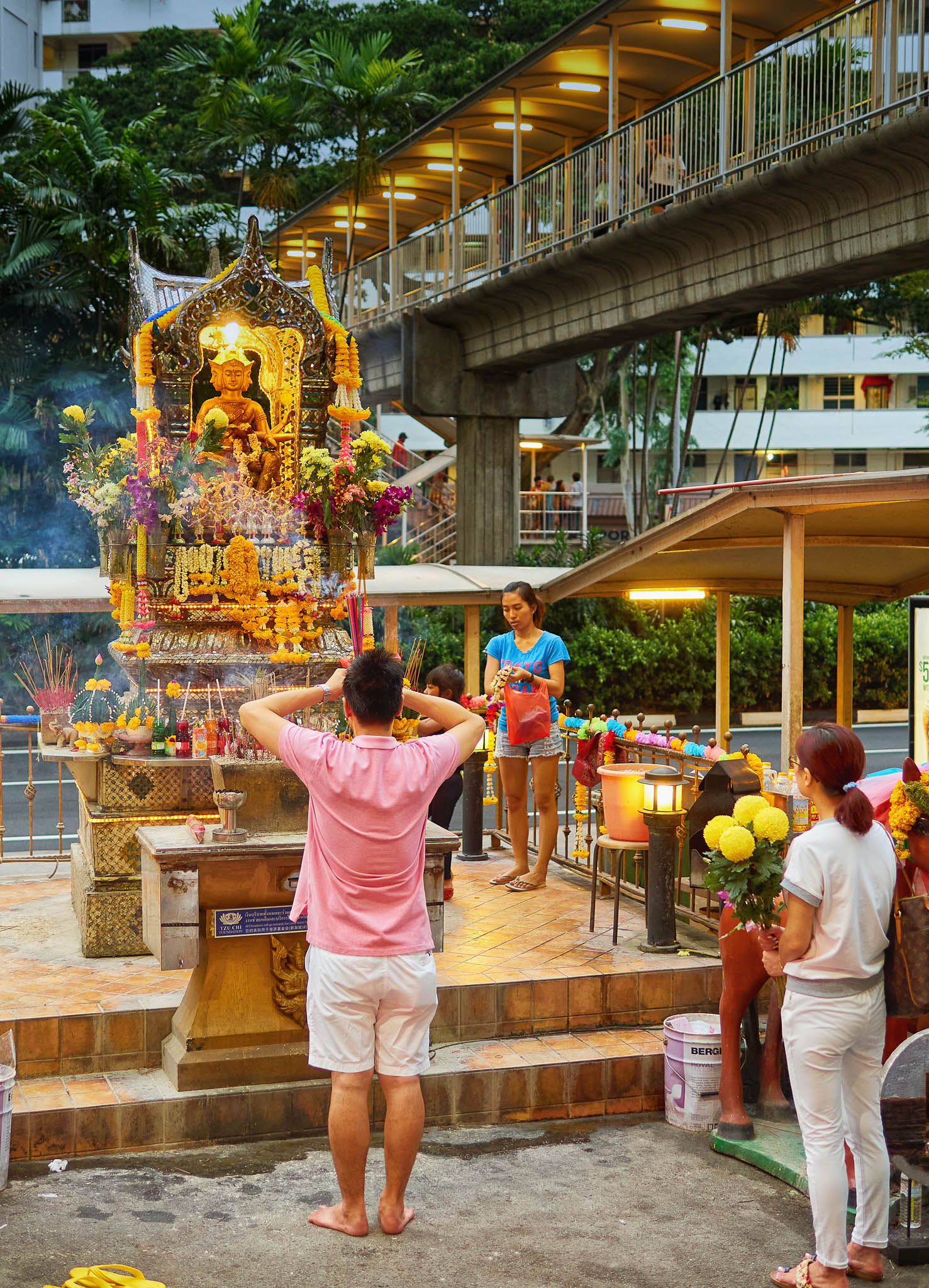 People worshipping Phra Phrom, the four faced Brahma, in the roadside Thai Buddhist temple, Golden Mile Complex, Beach Road, Singapore